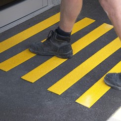 Person walking on yellow FRP anti-slip stair treads from OCEANFRP.